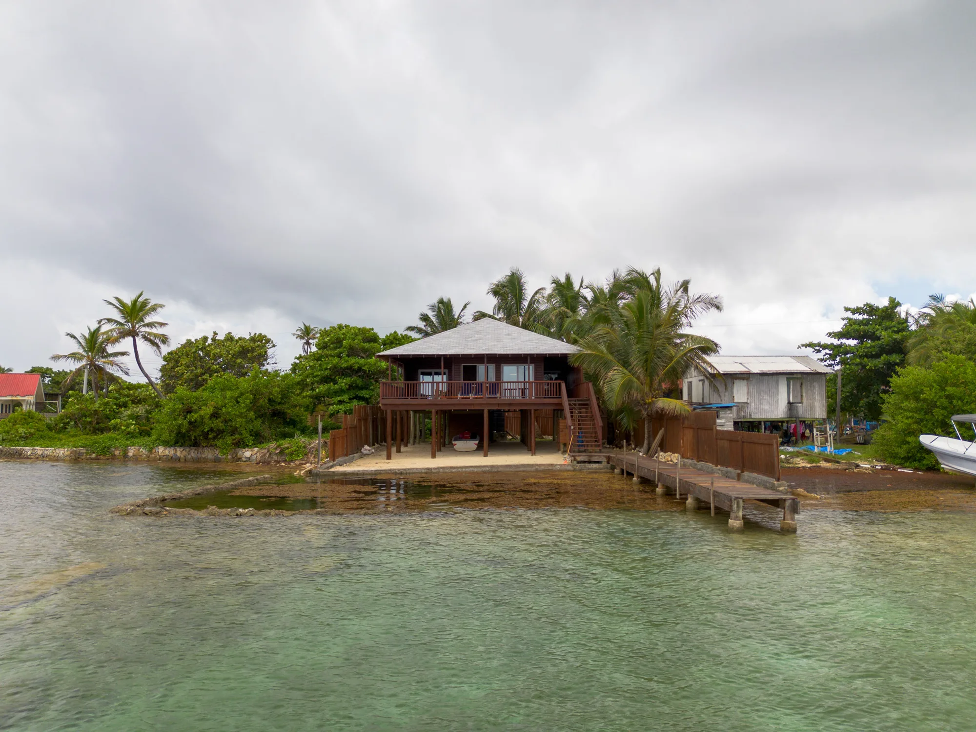 Stilted waterfront home over turquoise shallows at Calabash Bight, Roatán